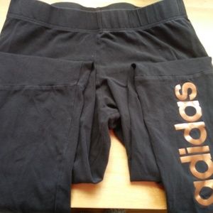 Black Adidas leggings with bronze logo on calf
